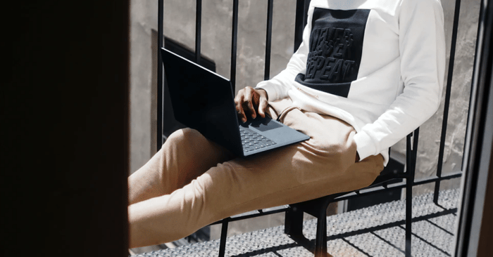 Man Sitting and Browsing on Laptop