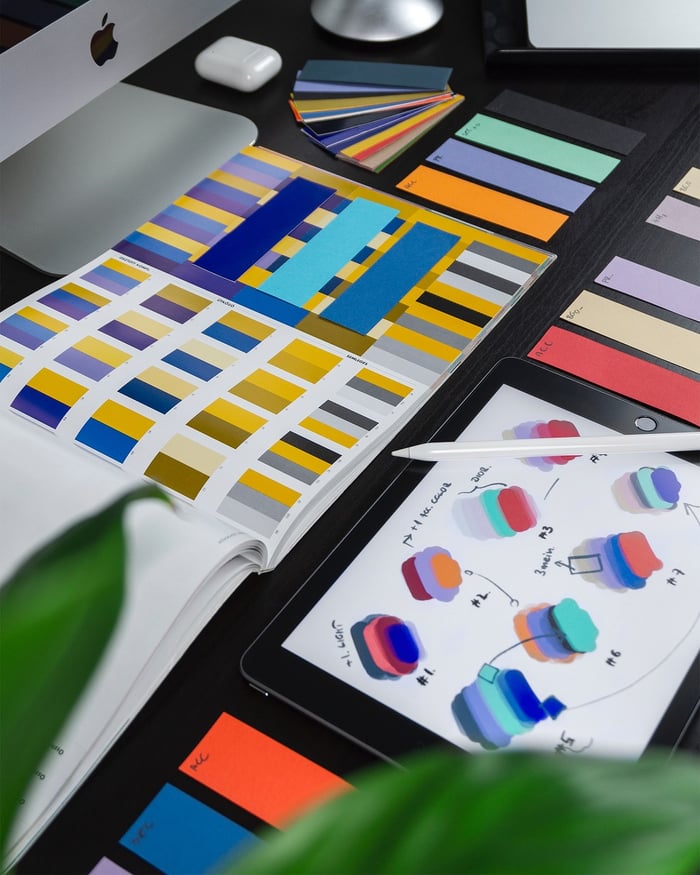 biurko obłożone albumami z paletami kolorów