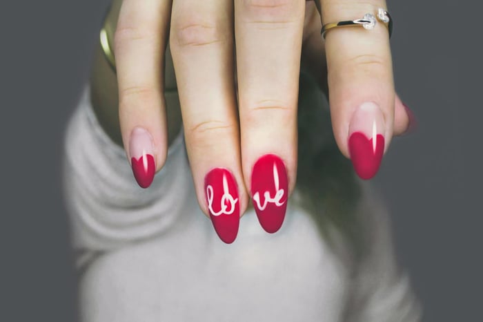 Red painted nails that spell out love