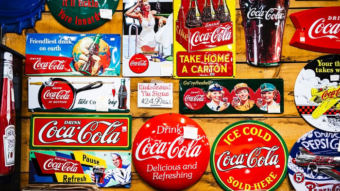 selection of old coca cola advertising nailed to wooden wall