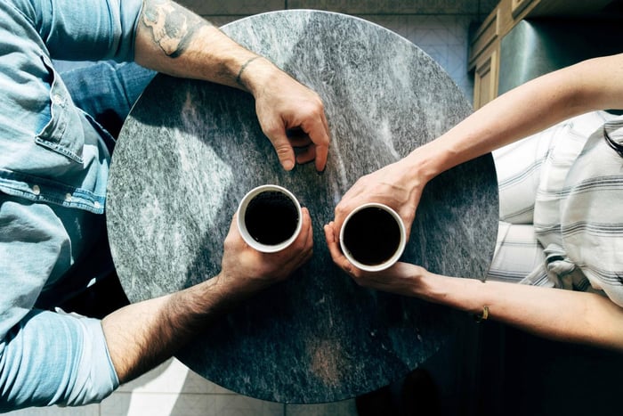 Two people having a coffee by a table