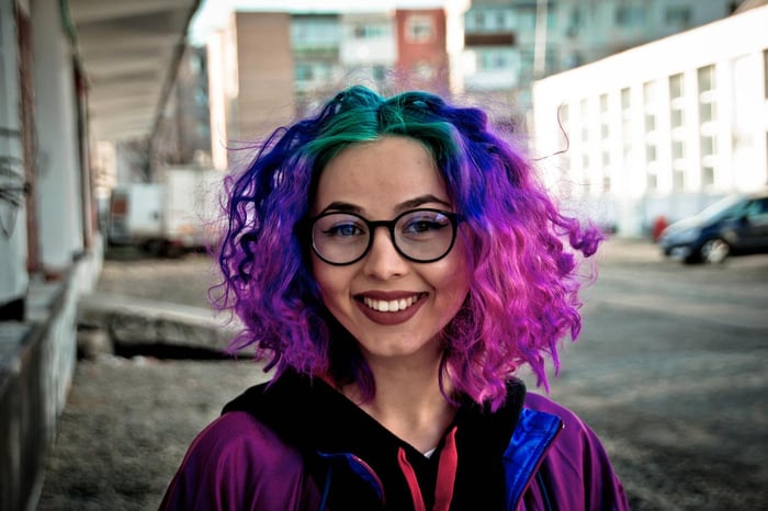 Mujer vistiendo una peluca colorida, verde azul violeta