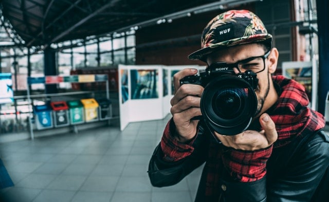 Jeune homme prenant une photo avec un appareil photo
