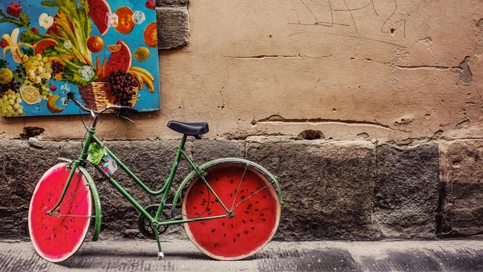 Bicycle painted like a watermelon parked on street
