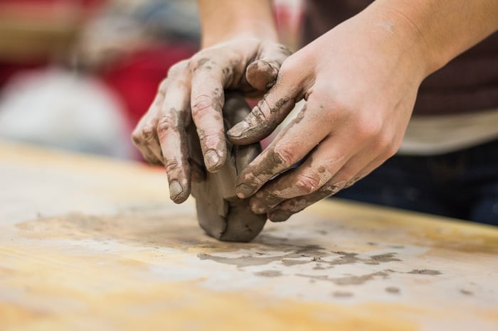 hands sculpting piece of clay