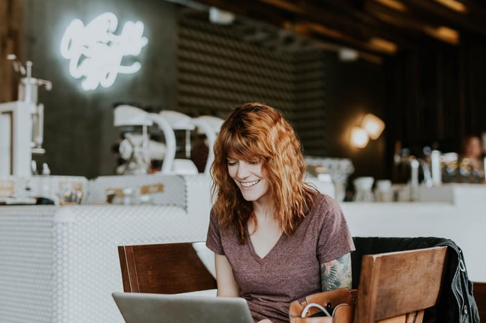 lachende vrouw met laptop in cafe