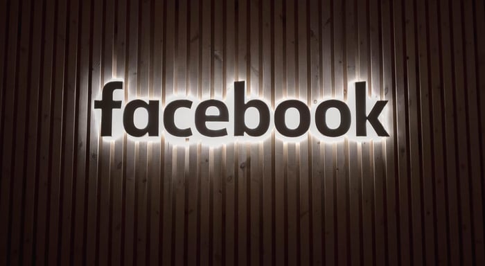 lit up facebook sign on wall