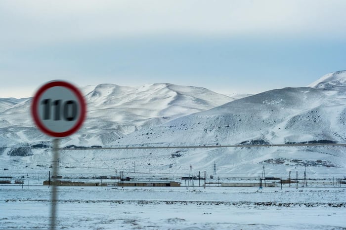 Paisaje nevado con señal de límite de velocidad borrosa
