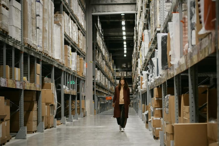 Woman Walking in the Isle of a Warehouse