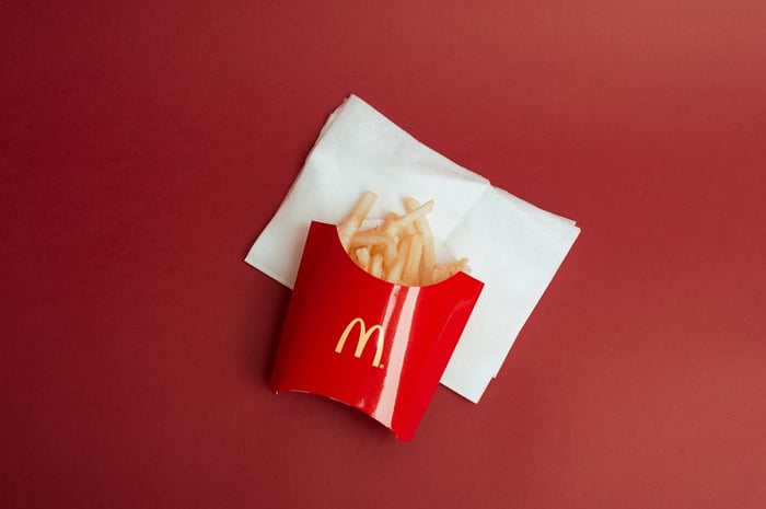batatas fritas na embalagem do McDonald's sobre uma mesa vermelha