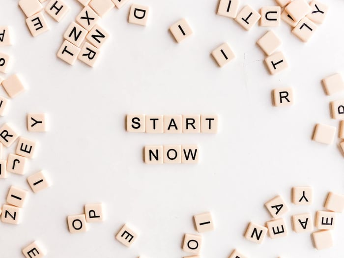 Image sur fond blanc ou il est écrit avec des lettres de Scrabble en anglais : Commencez maintenant 