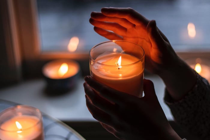 Hand Shielding a Candle in the Dark