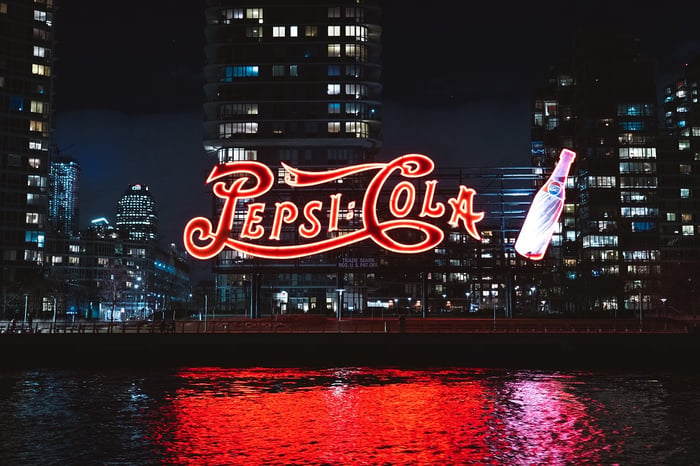 Gran cartel de Pepsi Cola iluminado delante de los rascacielos