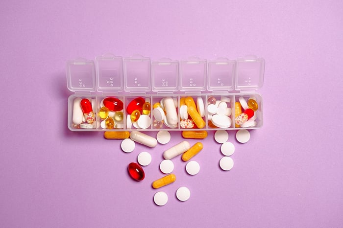 Pil vitamin di dalam wadah obat
