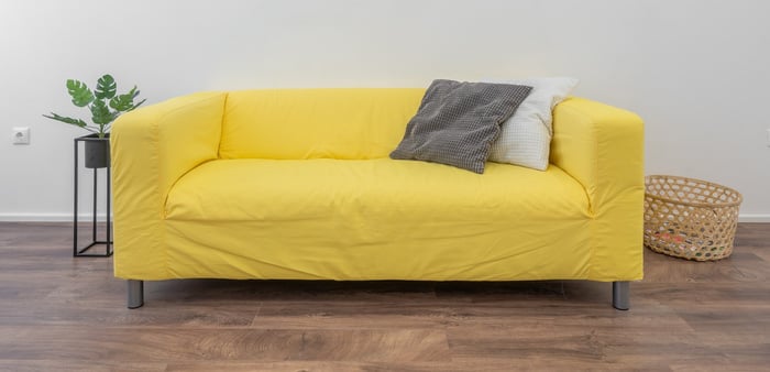 Sofa kuning dengan sarung sofa longgar
