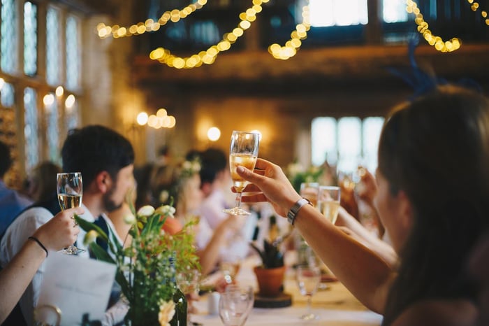 People cheering and raising a glass at a wedding