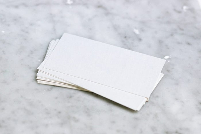 A pile of blank business cards on a marble table