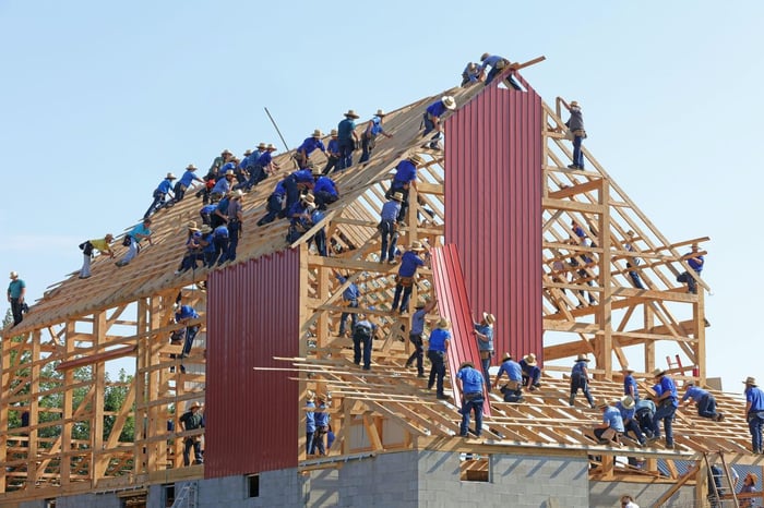 Group of people building a house outside