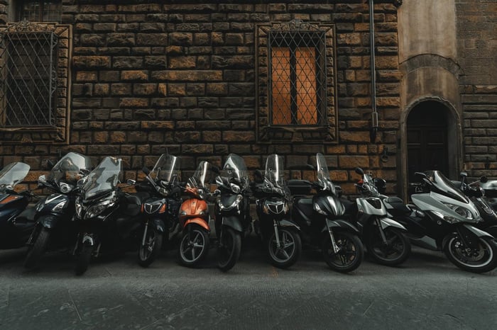 Mopeds standing at a brick wall
