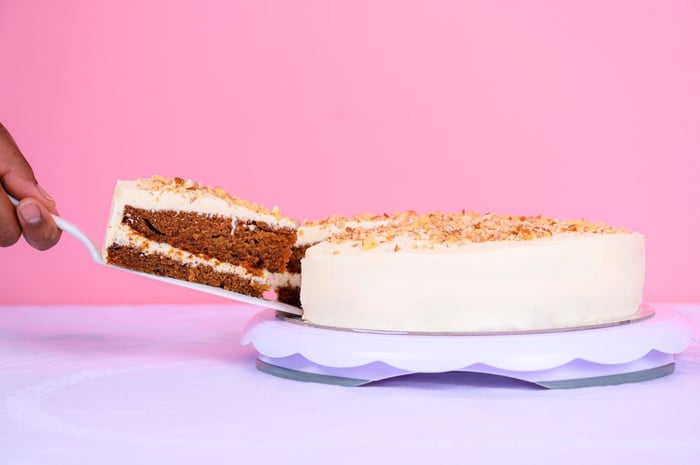 White cake on a table against a pink background