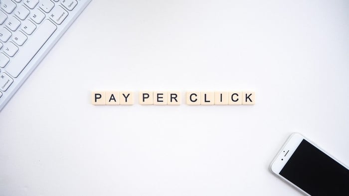 Mesa branca com bloquinhos formando as palavras "pay per click"