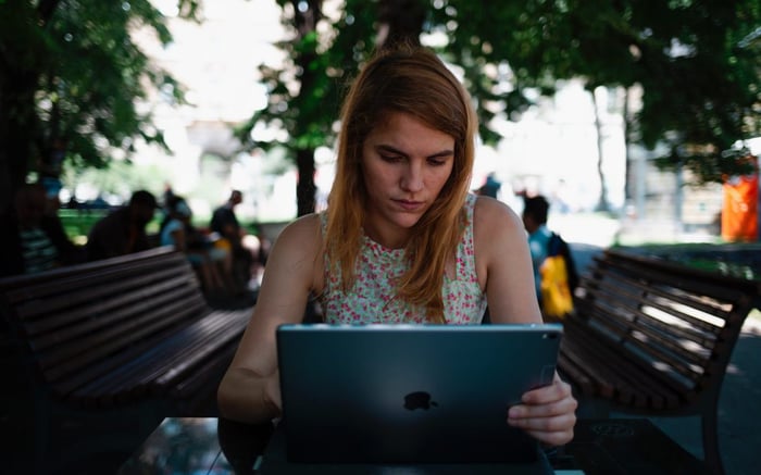 Girl on a laptop outside at a table