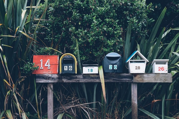 Mail boxes outside in front of a green bush