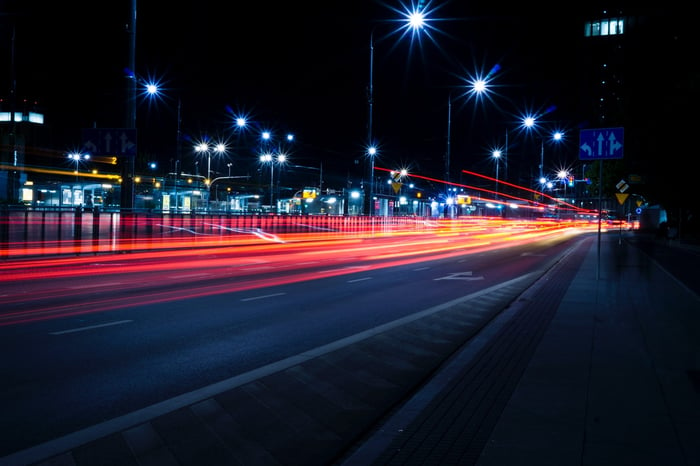 A night view of a city with cars speeding past