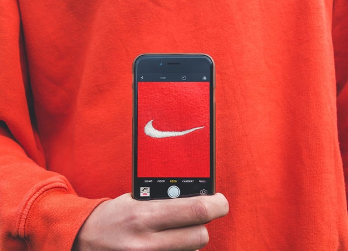 A red and white Nike logo displayed on a phone against a red shirt