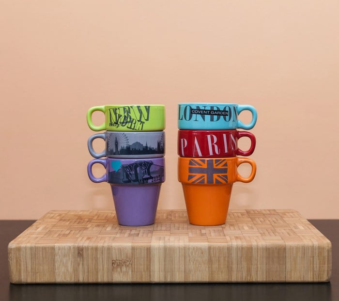 Stacked up mugs against a peach background