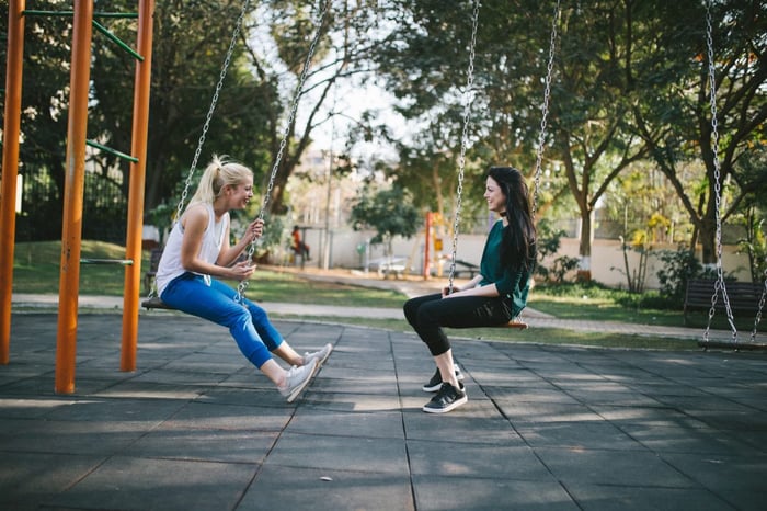 Two girls on swings outside