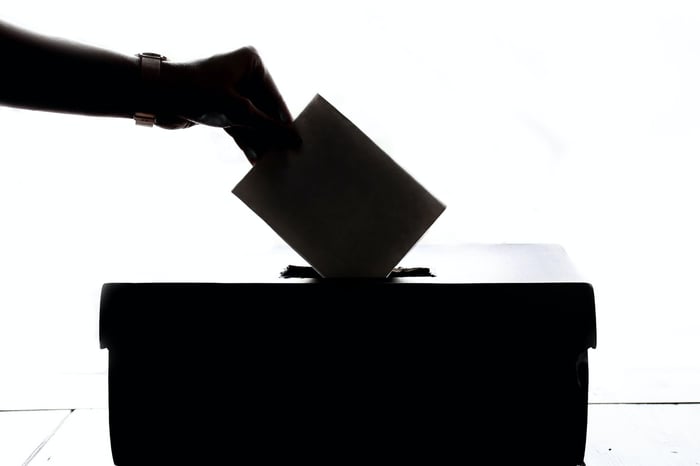 Ein Schwarz-Weiß-Wahllokal mit einer Hand, die eine Abstimmung abgibt
