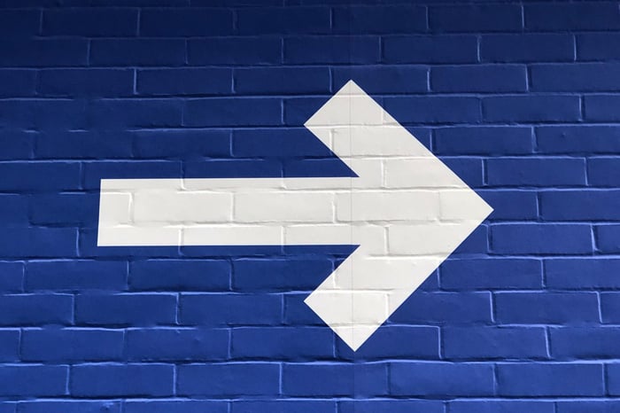 A big white arrow pointing right on a blue wall