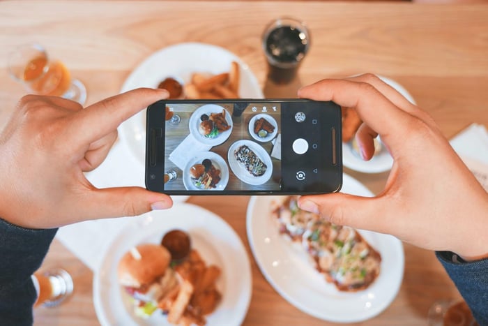 person taking landscape photo of plates of food