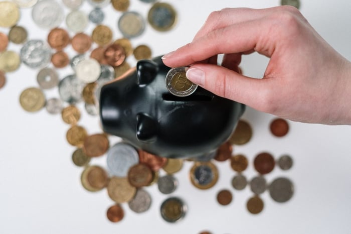 Um cofre de porquinho rodeadode moedas, visto de cima