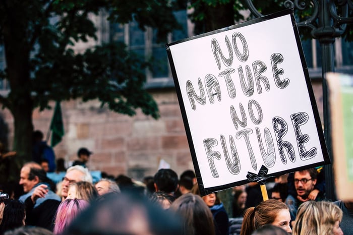 man holding up sign that says 'no nature no future'