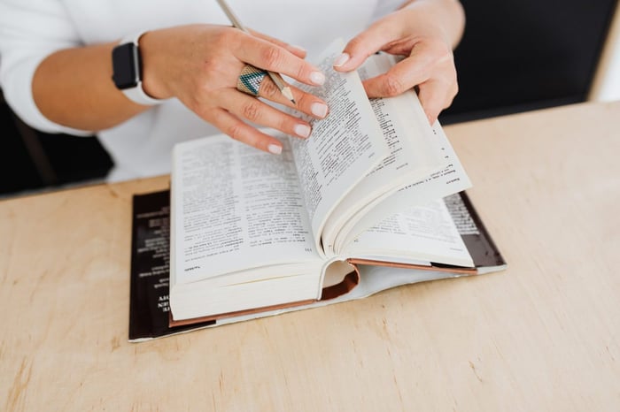 woman's hands flicking through dictionary