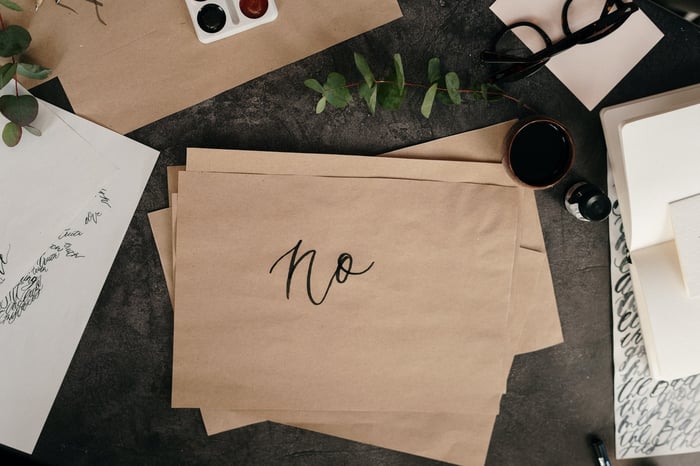 Papeles sobre un escritorio con una nota manuscrita que dice "no"