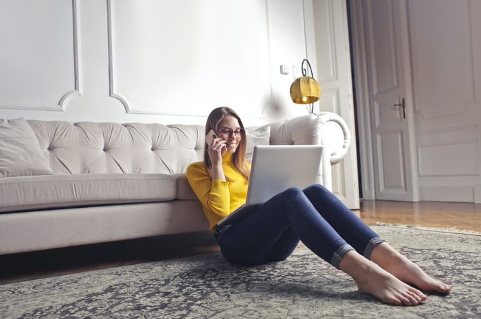 A girl sitting on the floor next to a sofa