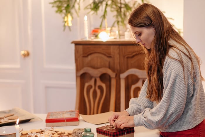 A girl wrapping up a gift indoors