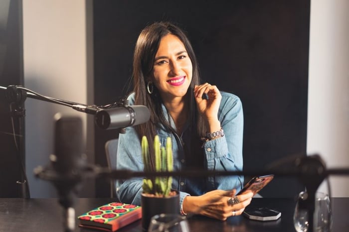 Mulher sorrindo em um estúdio de podcast