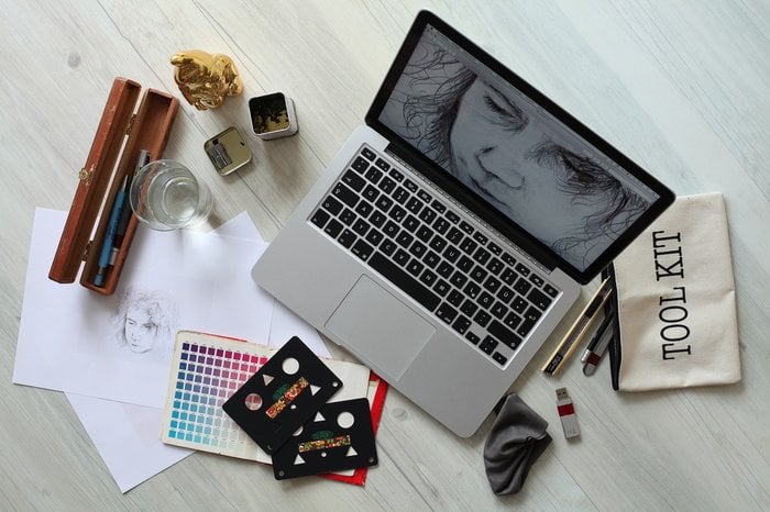 Notebook na mesa com design gráfico aberto na tela